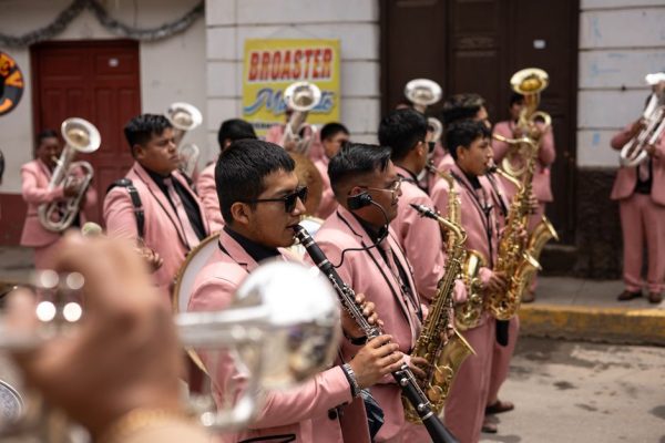 Brass band in pink suits performing on a lively city street parade.