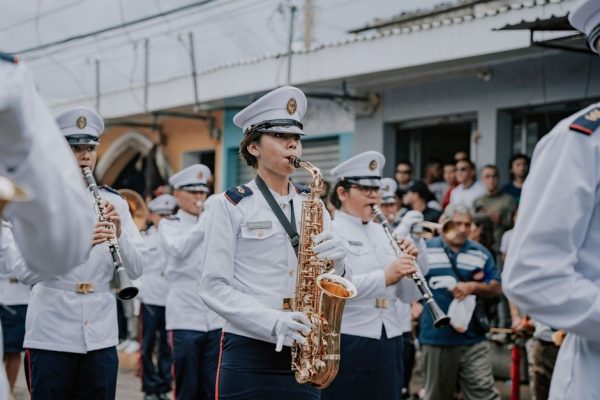 Military band playing saxophones and clarinets during a street parade in El Salvador.