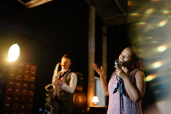 Intimate jazz performance featuring a saxophonist and a singer on stage, creating a mesmerizing ambiance.