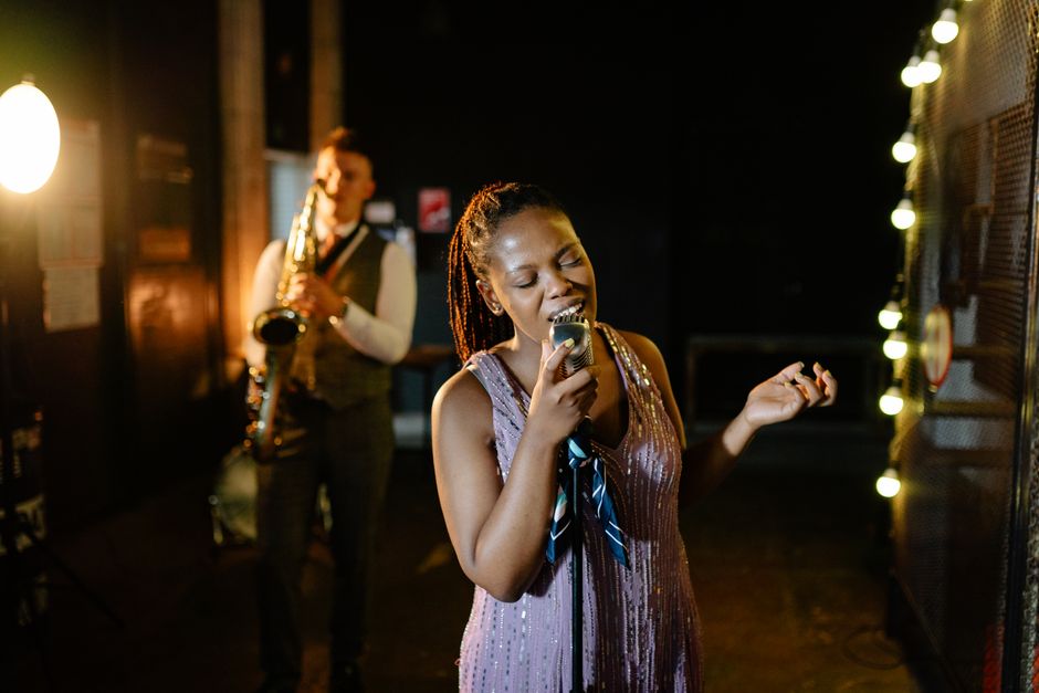 A captivating moment of a singer performing with a saxophonist in a dimly lit jazz venue.