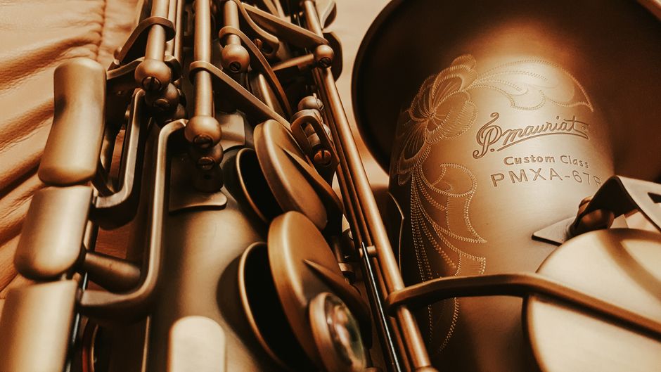 Close-up image of a vintage saxophone with intricate engraving, evoking classic musical elegance.