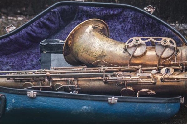 Closeup of a vintage brass saxophone in a velvet-lined case, highlighting its antique design.