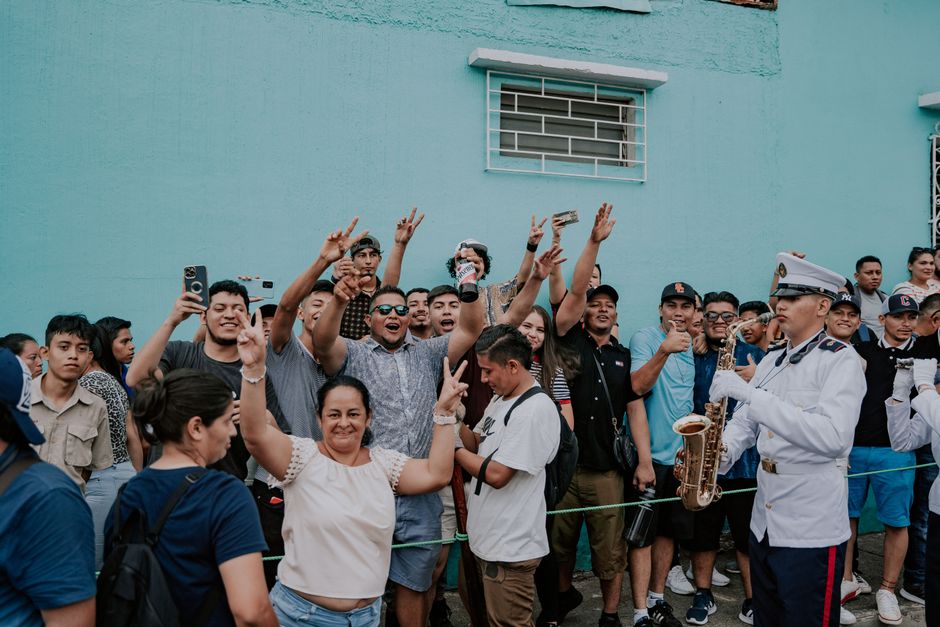 A festive street scene capturing a cheerful crowd at a parade, showcasing community spirit and celebration.