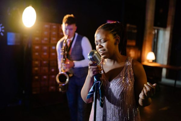 Dynamic live jazz show with soulful singer and saxophonist on stage.