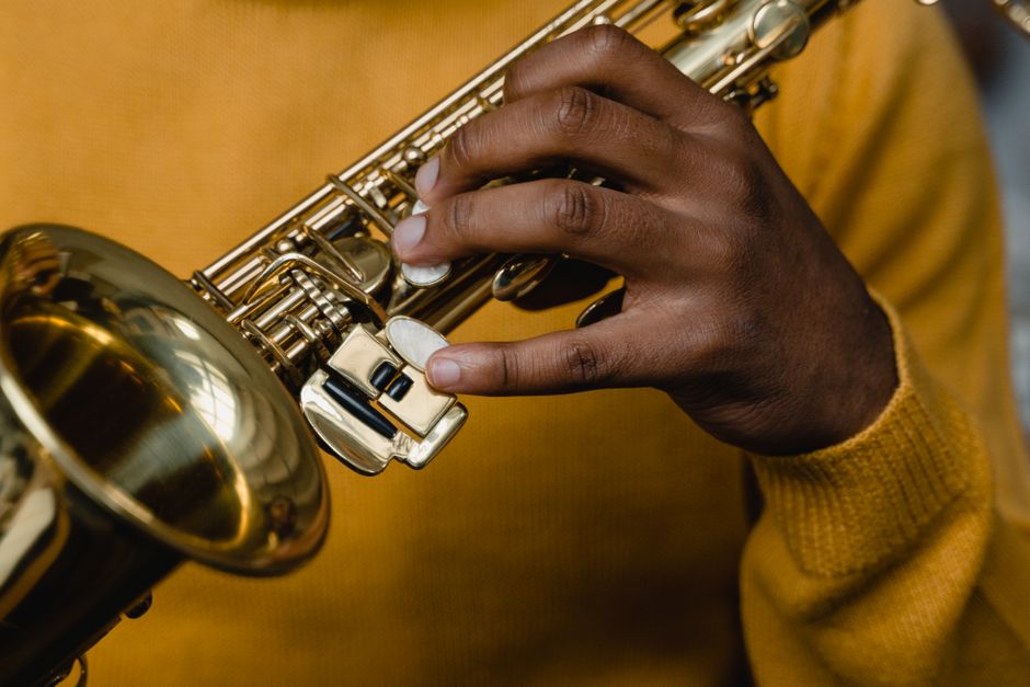 An adult musician plays a saxophone, highlighting skills and artistry.
