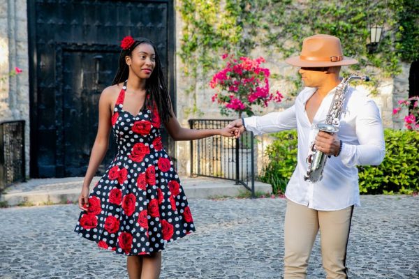 Stylish couple enjoying a romantic dance outdoors with saxophone music.