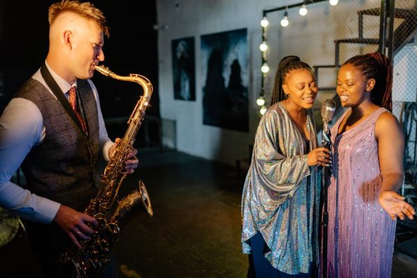 A group of musicians with saxophone and microphone performing indoors with elegance and energy.