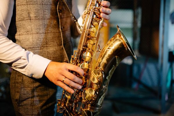 Detailed image of hands playing a golden saxophone, showcasing the intricate design and craftsmanship of the instrument.