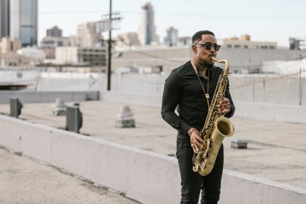 A musician plays saxophone on a city rooftop, creating a vibrant, urban vibe.