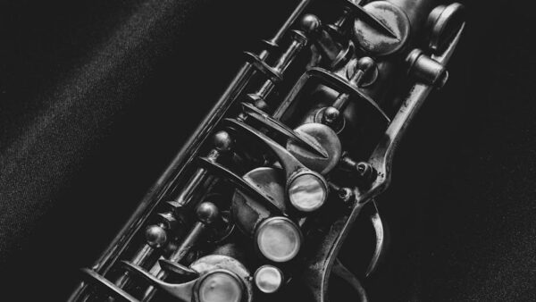 Artistic black and white close-up of saxophone keys, highlighting intricate details.