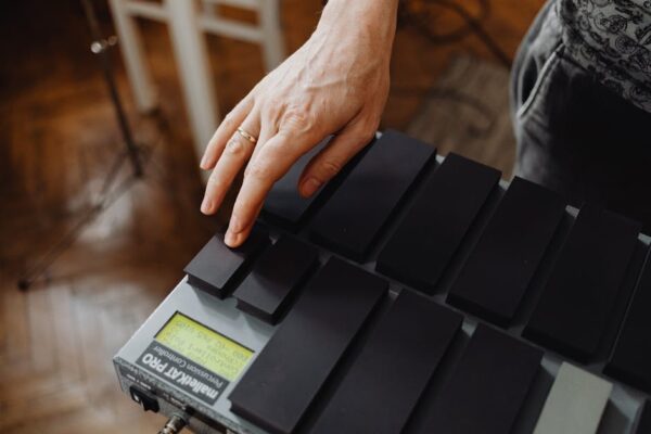 Close-up of a hand playing the MalletKat electronic percussion instrument indoors.