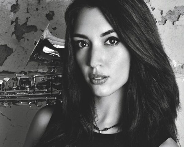 Elegant black and white portrait of a woman saxophonist with a textured background.