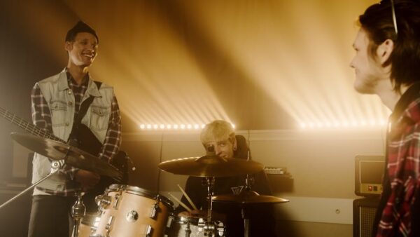 Musicians enjoying energetic rehearsal with instruments in a warmly lit studio.