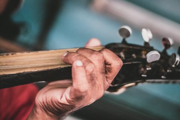 Detailed shot of a hand playing guitar strings, highlighting skill and artistry.