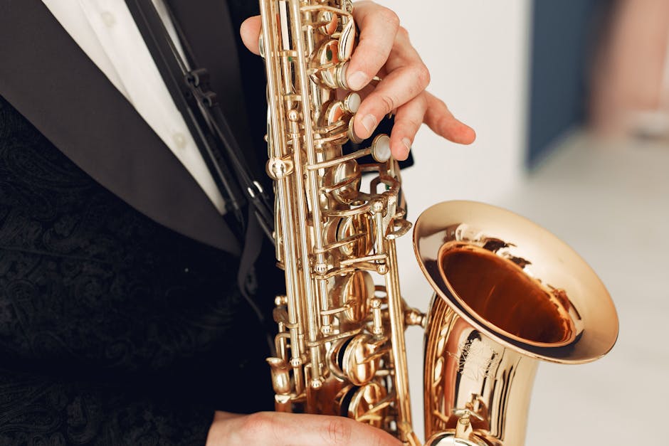 Close-up of a musician in a black suit playing a saxophone indoors, showcasing refined elegance.