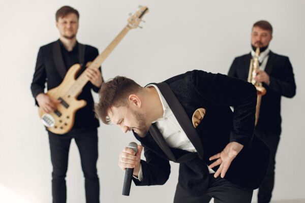 Energetic music band with singer, guitarist and saxophonist performing indoors.