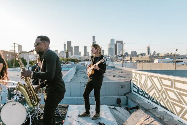 Indie band performing on a rooftop with the Los Angeles skyline at sunset.