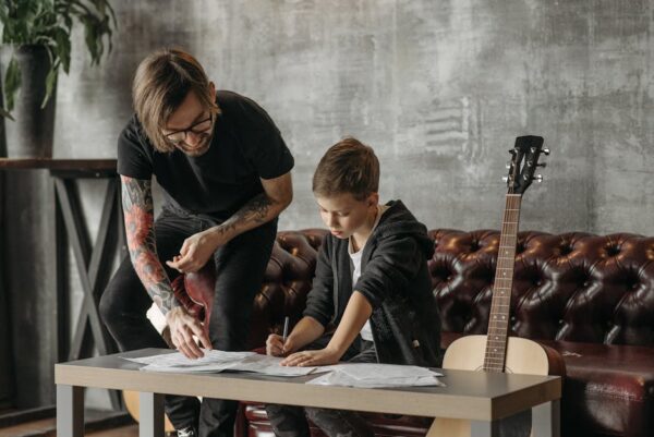 A teacher guides a child on guitar lessons indoors, fostering musical growth.