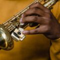 An adult musician plays a saxophone, highlighting skills and artistry.