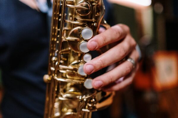 A close-up view of a hand playing a saxophone, emphasizing the musical interaction.