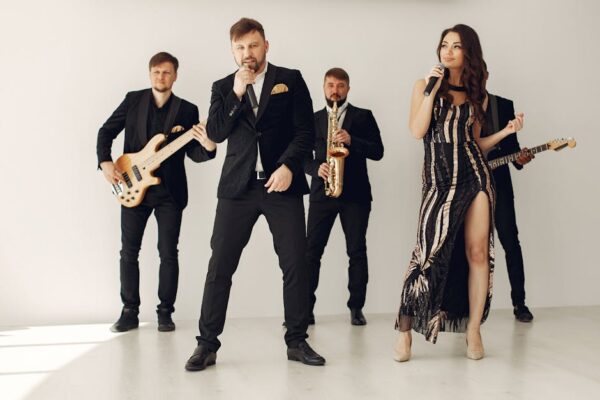 A stylish music band performing with vocalists and musicians in formal attire.