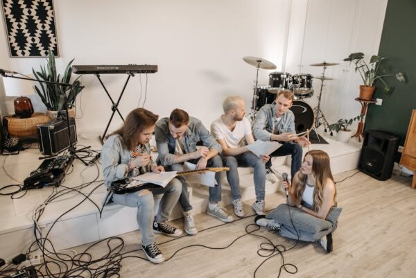 A group of young musicians practicing in a modern studio with various instruments.