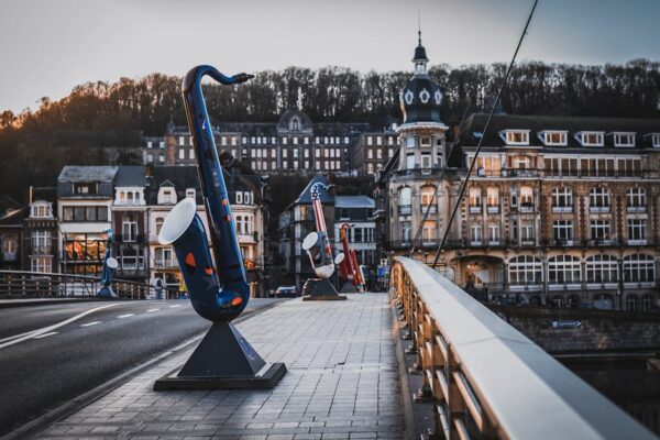Colorful saxophone sculptures adorn the Charles de Gaulle Bridge in scenic Dinant, Belgium.
