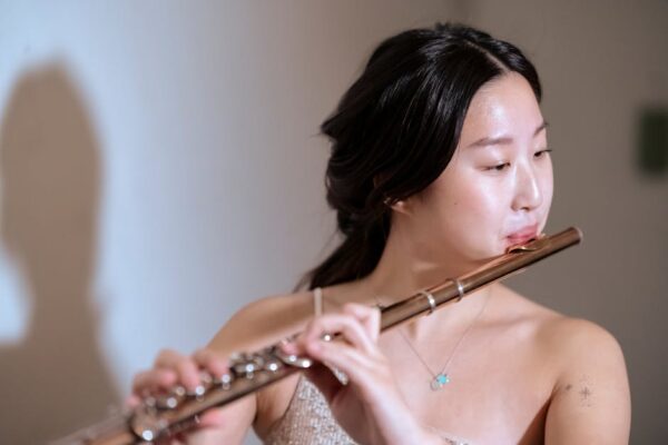 Portrait of a young woman playing the flute, showcasing skill and artistry.