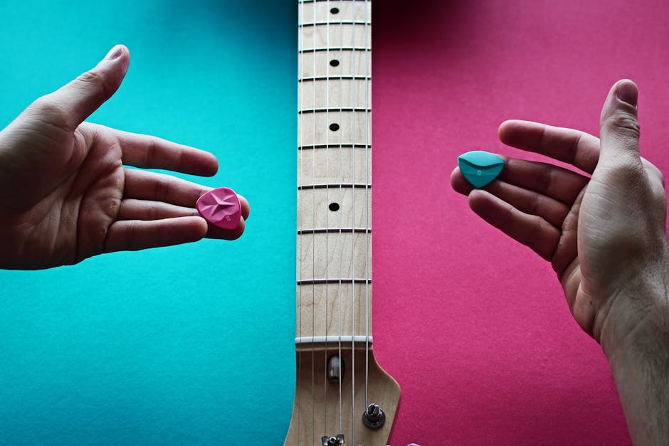 Close-up of hands holding colorful guitar picks over an electric guitar neck.