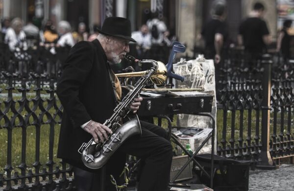 Elderly musician playing saxophone in Prague's lively streets, capturing the essence of street art.