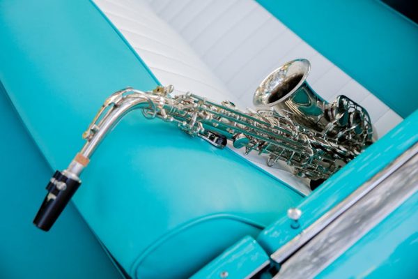 A saxophone elegantly placed on the seat of a vintage convertible, exuding a retro vibe.