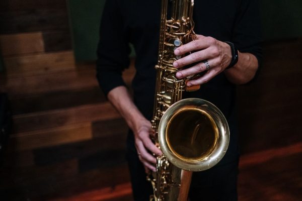 Musician playing saxophone in a cozy indoor setting, showcasing musical passion.